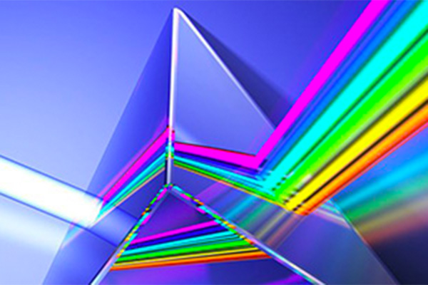A rainbow of colors crossing through a glass pyramid.