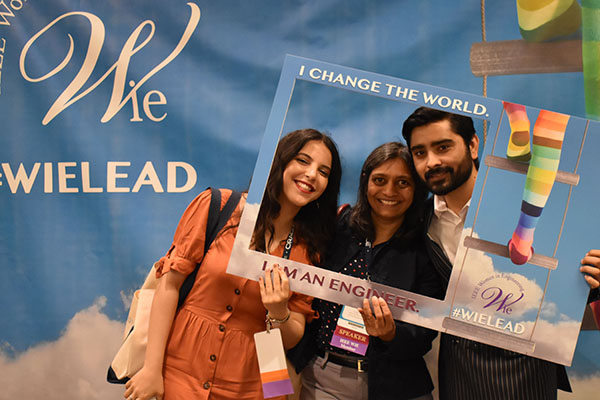 Three people pose for photographs at the ILC 2019 conference.