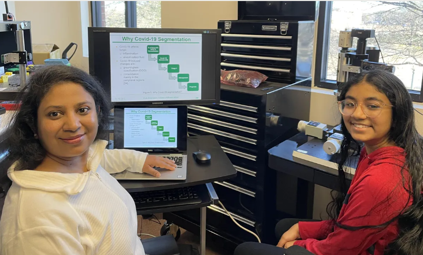 Bhuvan Mittal (left) reviewing her dissertation slides while her daughter is working on the laboratory's optical electronic equipment. PRITHA KHURANA