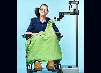 Man in wheelchair is covered by a blanket via the Stretch robot.