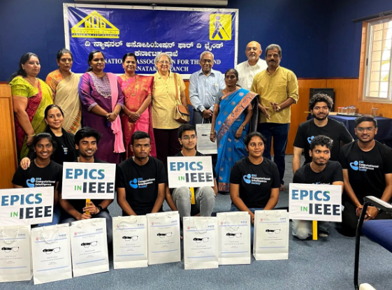 The EPICS in IEEE team displays posters that explain how its OurVision wearable device works. In the background are representatives from the National Association for the Blind and faculty members from the Ramaiah Institute of Technology in Bangalore, India.