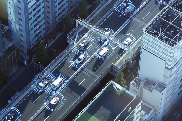 An overhead view of a city, showing cars with motion lines around them indicating connectivity.