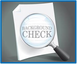 A magnifying glass held over the words Background Check on a white piece of paper.